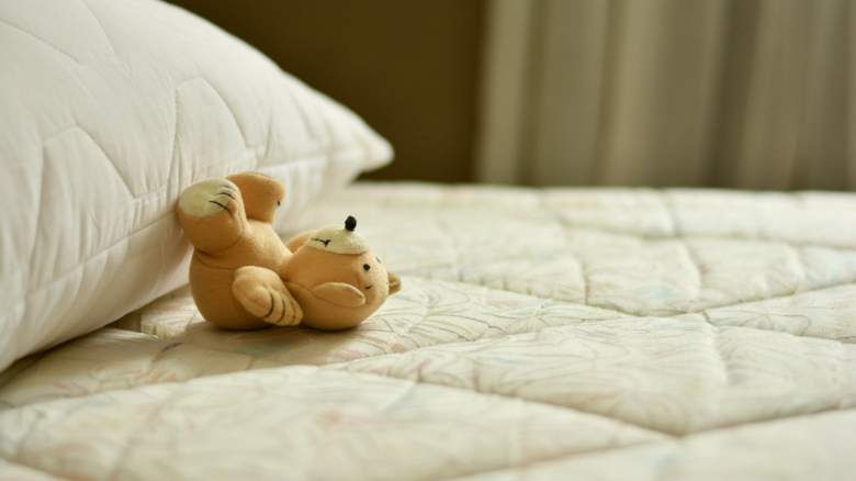 A teddy bear on a mattress.