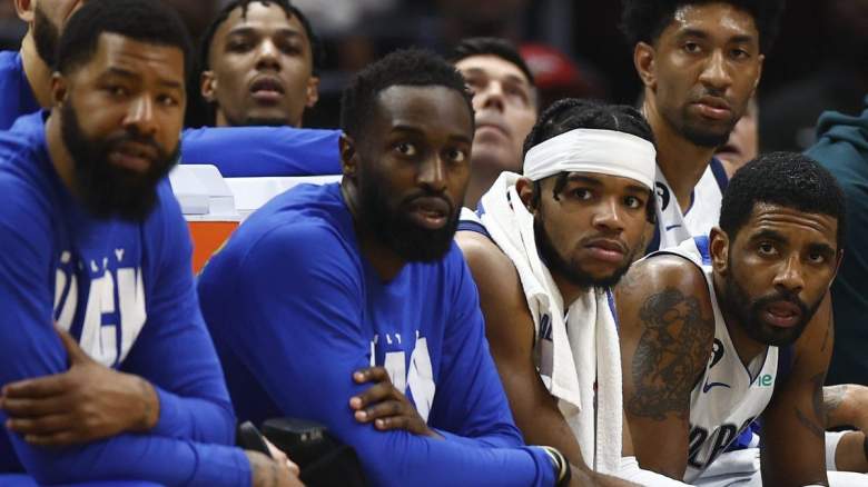 Kyrie Irving sits on the bench with his Dallas Mavericks teammates.