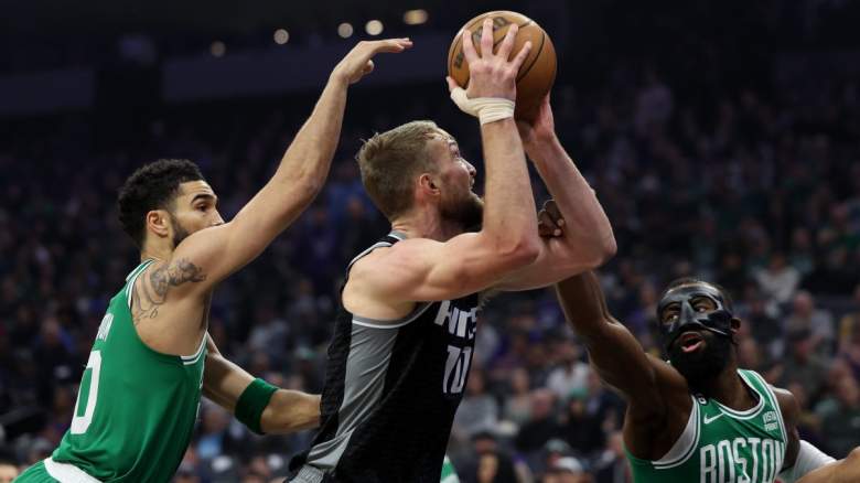 Celtics' Jayson Tatum and Jaylen Brown guarding Domantas Sabonis of the Kings