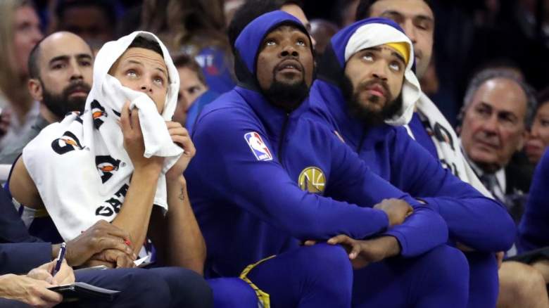 Stephen Curry and Kevin Durant sit on the Golden State Warriors bench.