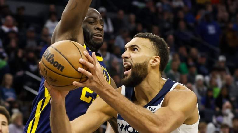 Draymond Green of the Golden State Warriors defends Minnesota Timberwolves center Rudy Gobert.