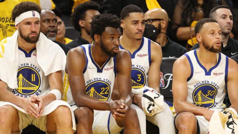 Klay Thompson, Andrew Wiggins, Jordan Poole, and Stephen Curry sit on the Golden State Warriors' bench.