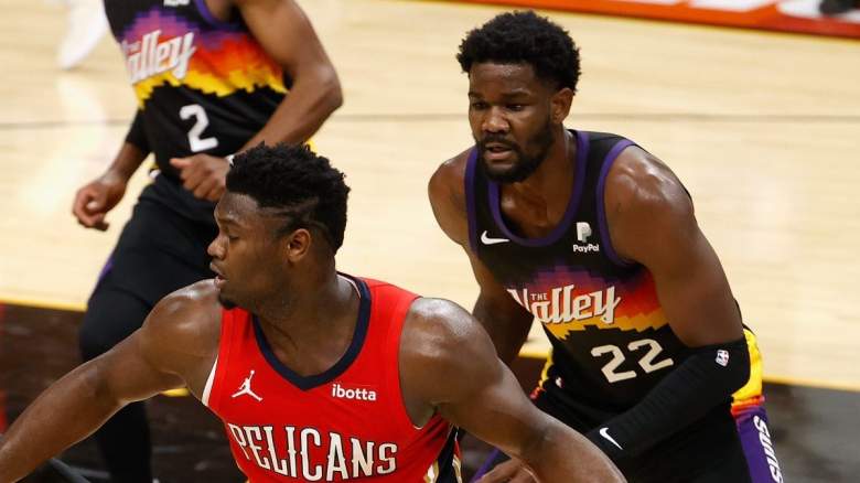 New Orleans Pelicans star Zion Williamson is defended by Deandre Ayton of the Phoenix Suns.