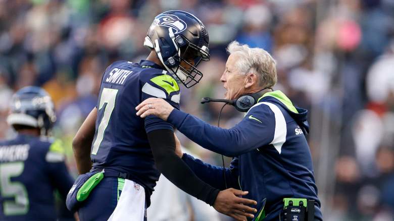 Seahawks QB Geno Smith and head coach Pete Carroll celebrating together.