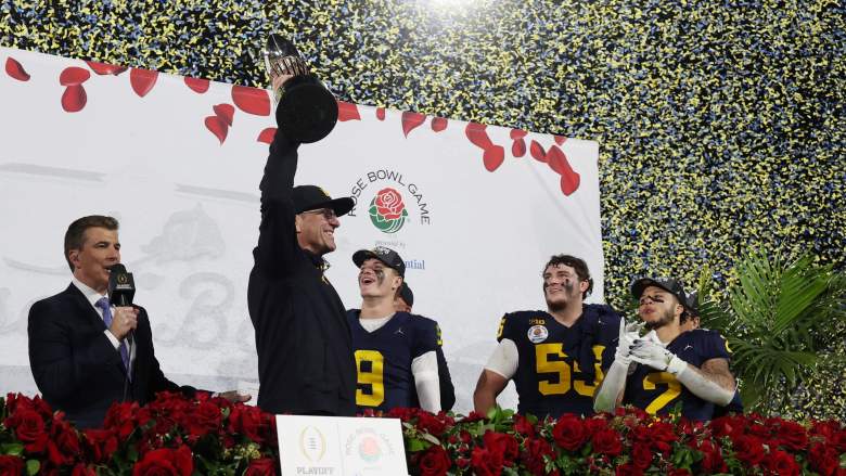 Michigan head coach Jim Harbaugh hosting trophy after win over Alabama in Rose Bowl.