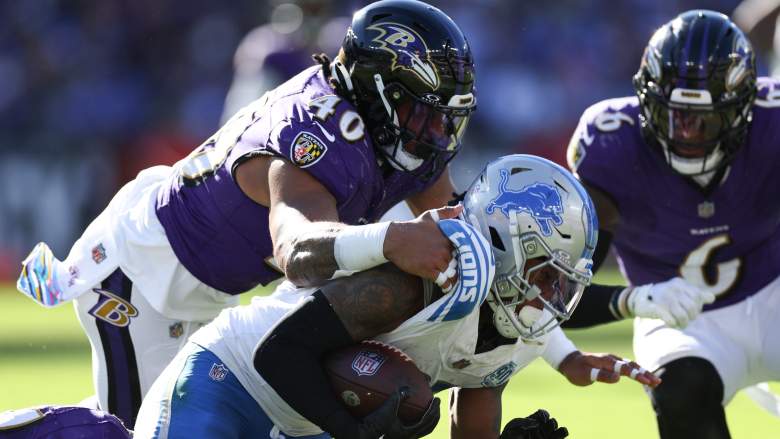 Ravens LBs Malik Harrison and Patrick Queen tackle Lions RB Jahmyr Gibbs.