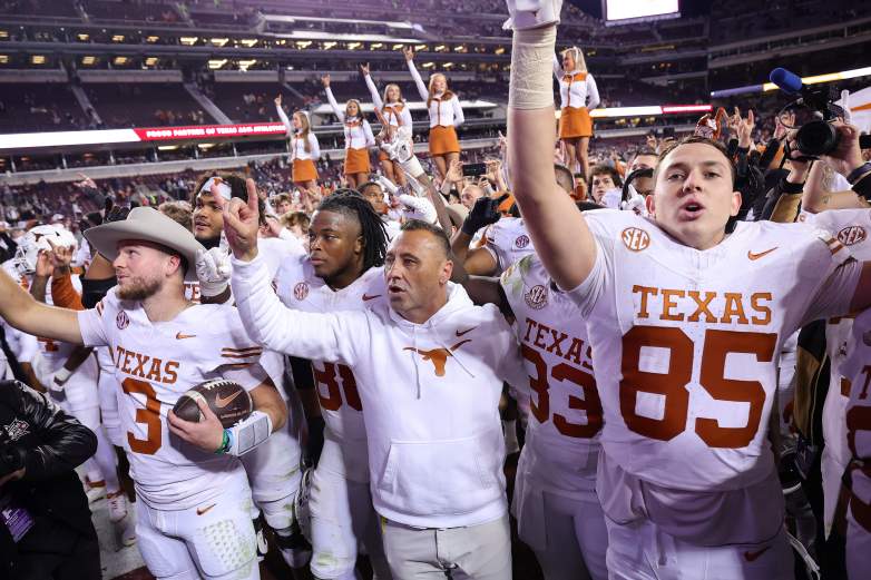 Quinn Ewers #3 and Coach Steve Sarkisian of the Texas Longhorns celebrate with teammates and the fans after defeating the Texas A&M.