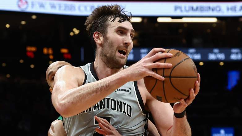 Derrick White #9 of the Boston Celtics reaches around but can't steal the ball from Luke Kornet #7 of the San Antonio Spurs