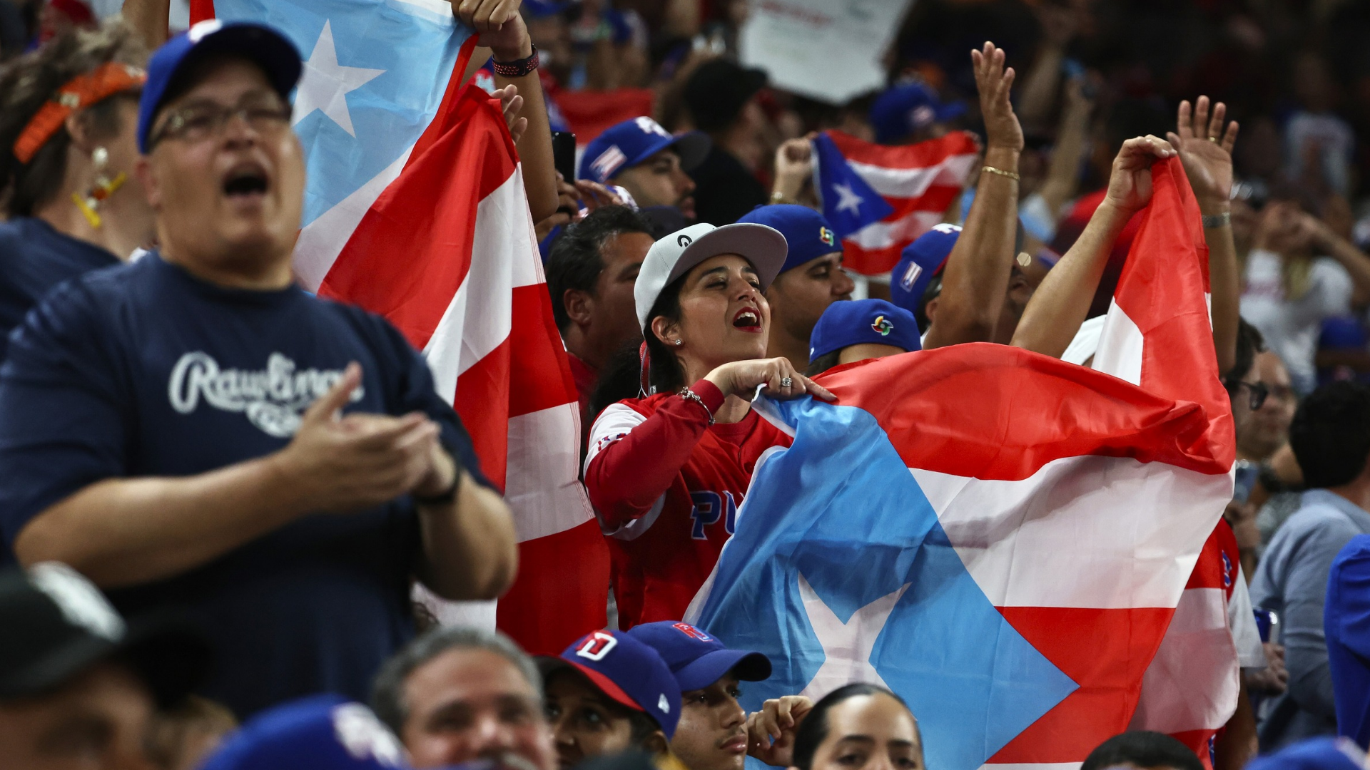 Puerto Rico fans celebrate in the stands during a World Baseball Classic game, highlighting the passion at stake as the team considers withdrawing in 2026.