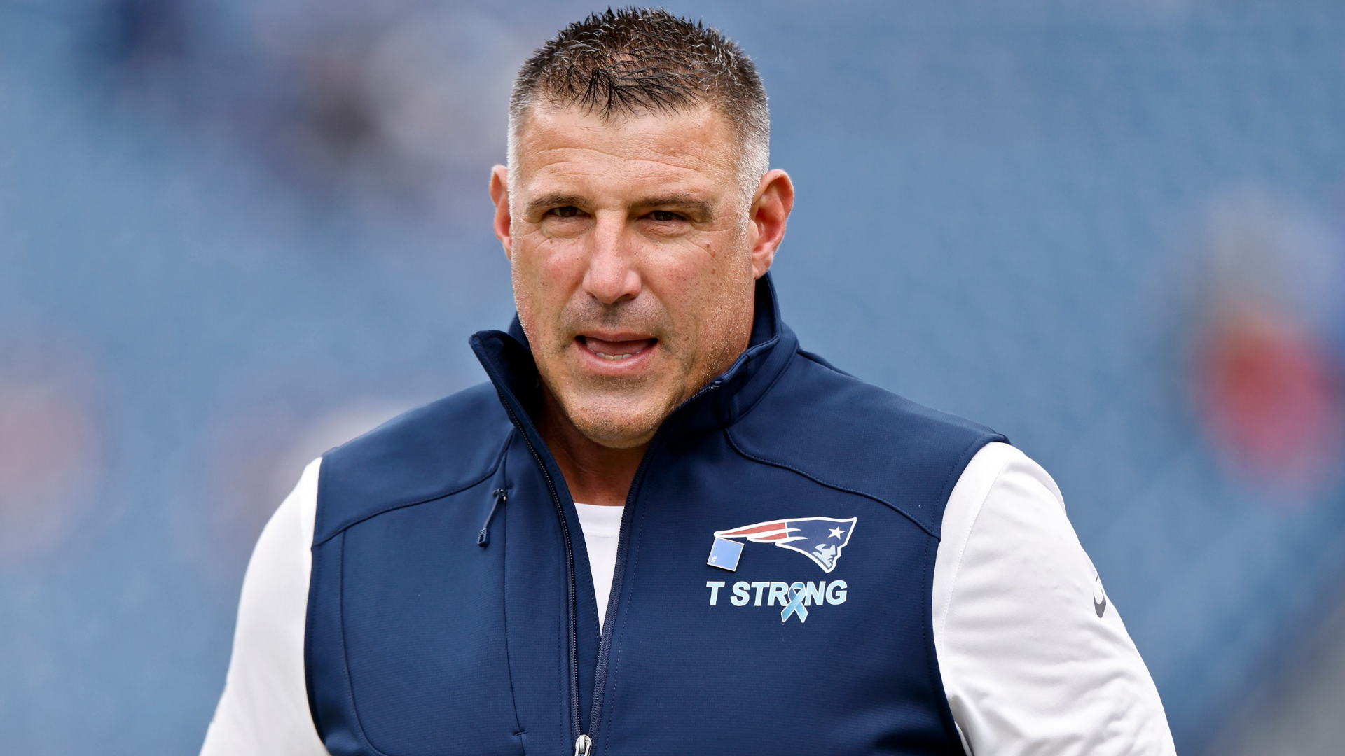 Why does Mike Vrabel wear a T Strong patch? A tribute and resilience symbol.
