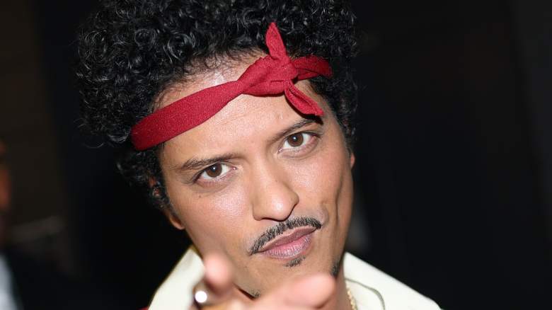Bruno Mars points to the camera.
