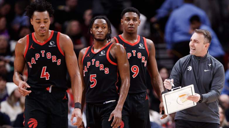 Darko Rajakovic, head coach of the Toronto Raptors, talks with Scottie Barnes, Immanuel Quickley, and RJ Barrett
