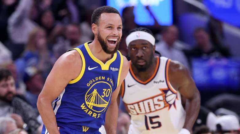 Stephen Curry of the Golden State Warriors reacts after making on Mark Williams of the Phoenix Suns.