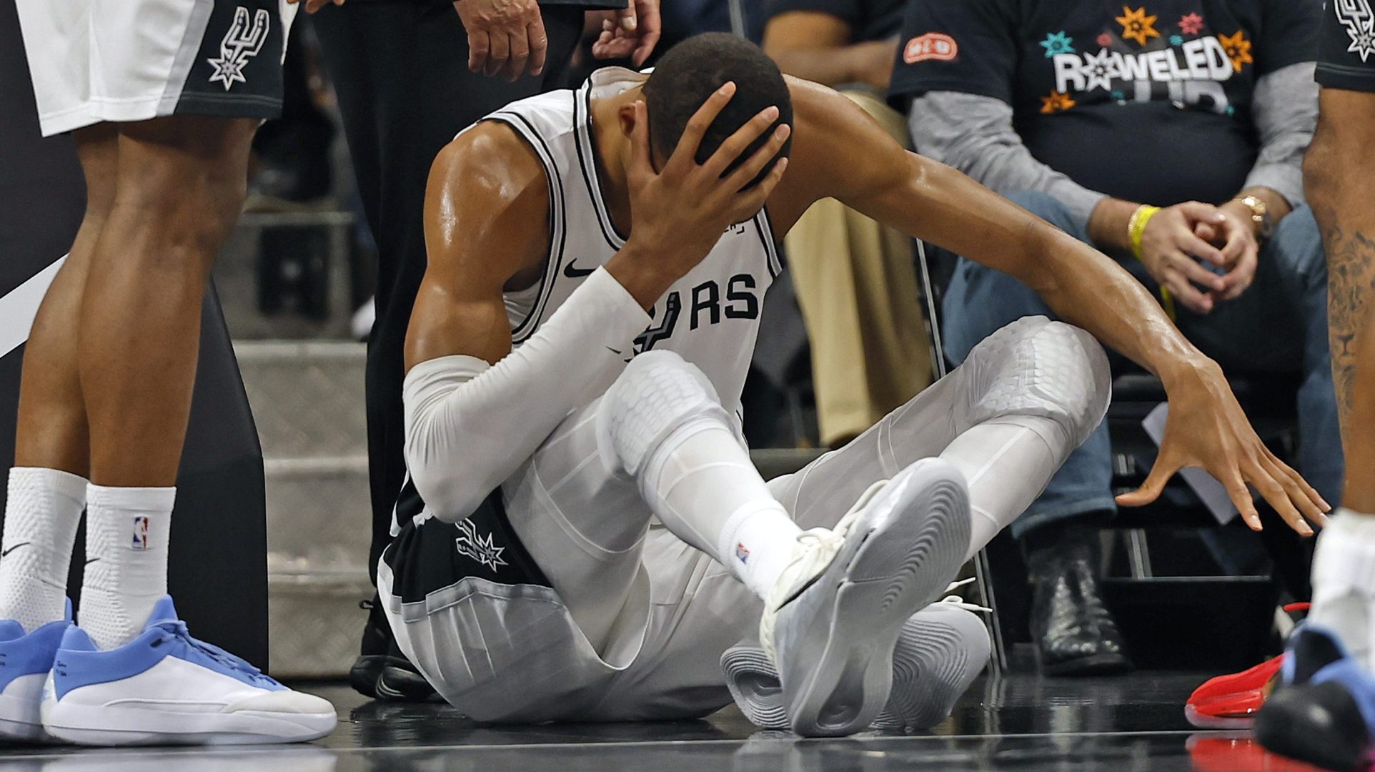 Victor Wembanyama sits on the court after a fall as the Spurs star entered concussion protocol during a playoff game