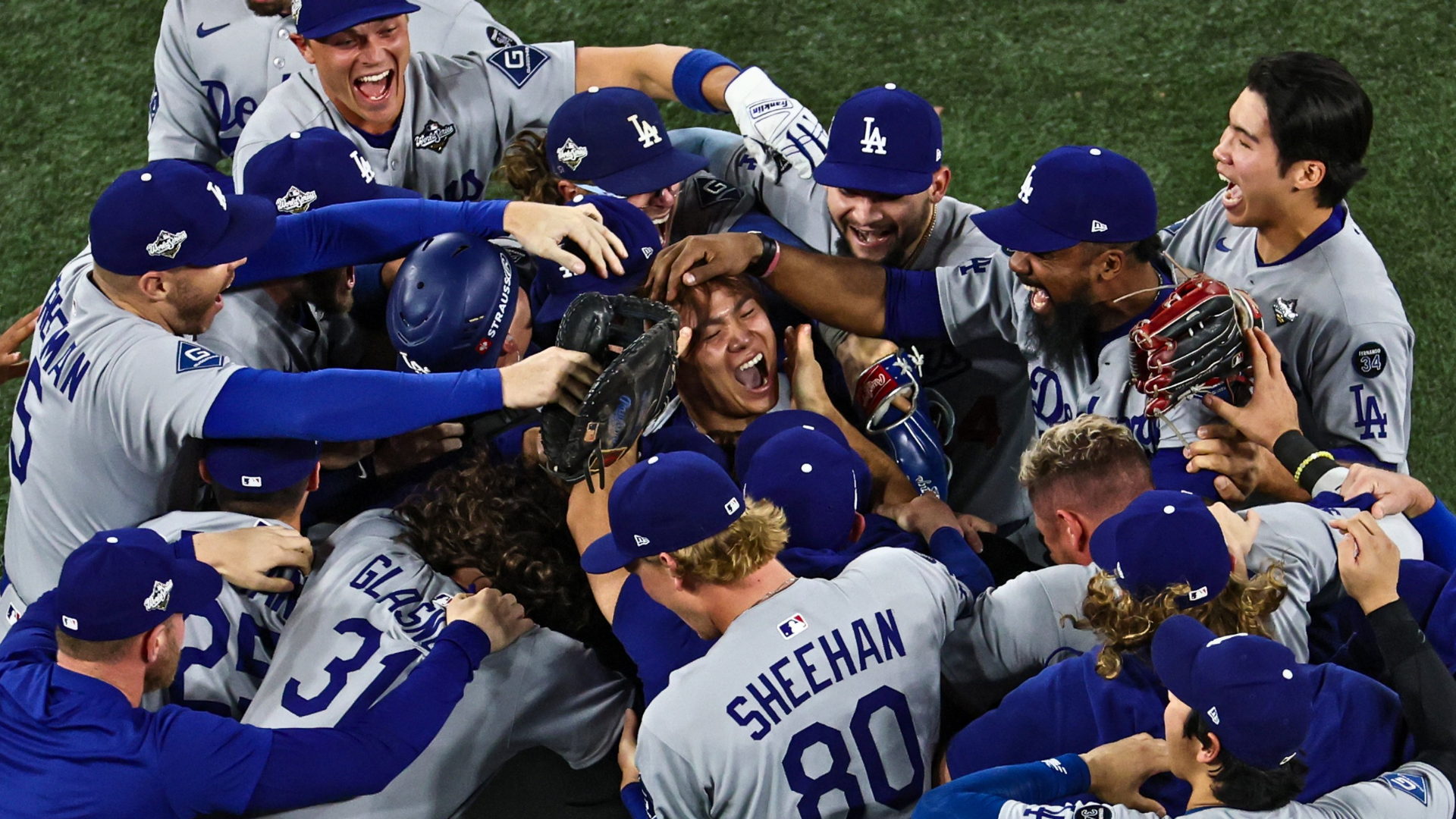 Pitcher Yoshinobu Yamamoto #18 of the Los Angeles Dodgers (R) celebrates with teammates after defeating the Toronto Blue Jays, 5-4, in game seven of the 2025 World Series at Rogers Center on November 02, 2025 in Toronto, Ontario. (Photo by Patrick Smith/Getty Images)