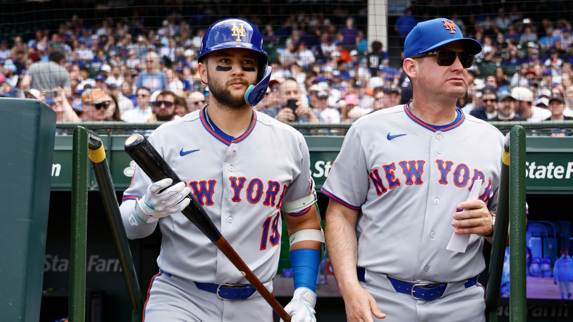 Bo Bichette #19 and manager Carlos Mendoza #64 of the New York Mets lookon prior to the game against the Chicago Cubs at Wrigley Field on April 17, 2026 in Chicago, Illinois. (Photo by Michael Reaves/Getty Images)