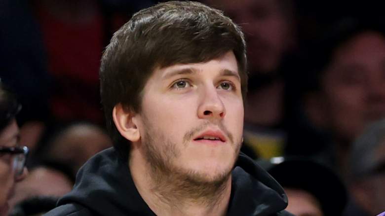 Austin Reaves watches from the bench in street clothes during a Los Angeles Lakers game.