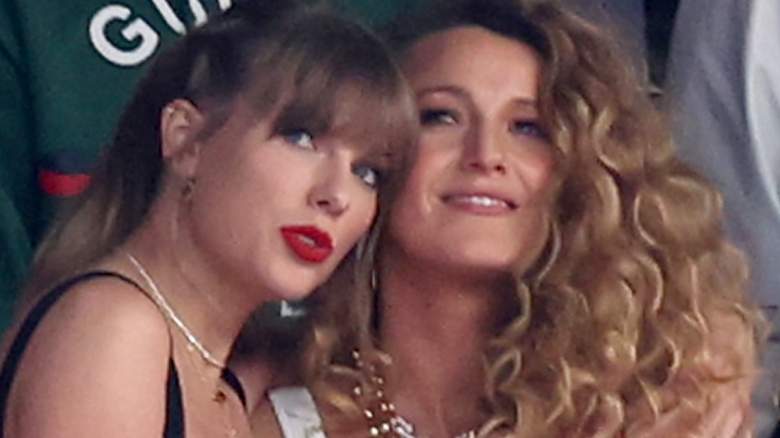 Taylor Swift and Blake Lively hug at a football game.