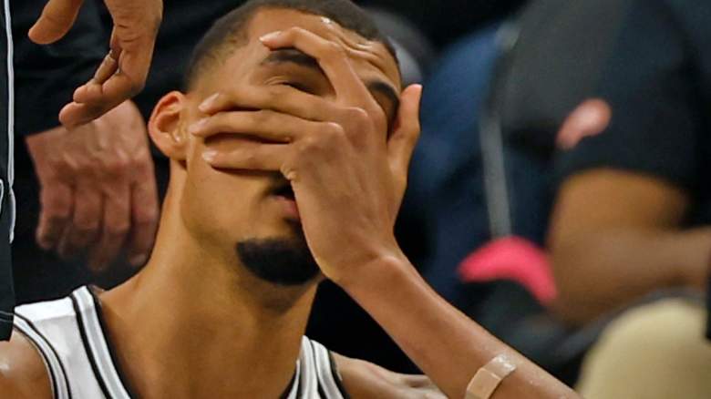 Victor Wembanyama holds his head after a concussion,