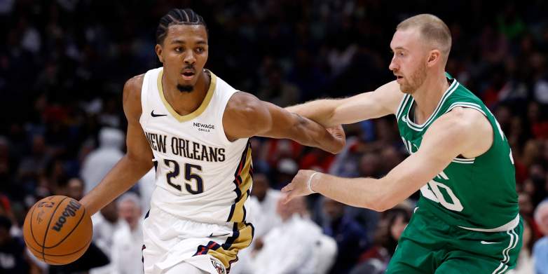 New Orleans Pelicans forward Trey Murphy III dribbles past Boston Celtics guard Sam Hauser during an NBA game.