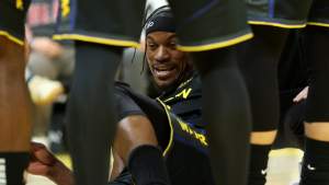 Jimmy Butler III #10 of the Golden State Warriors is looked at by teammates and trainers after he collided with Davion Mitchell #45 of the Miami Heat and injured his knee.