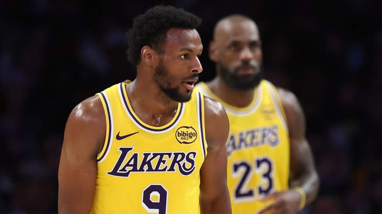 Bronny James in Lakers uniform with LeBron James in background during game