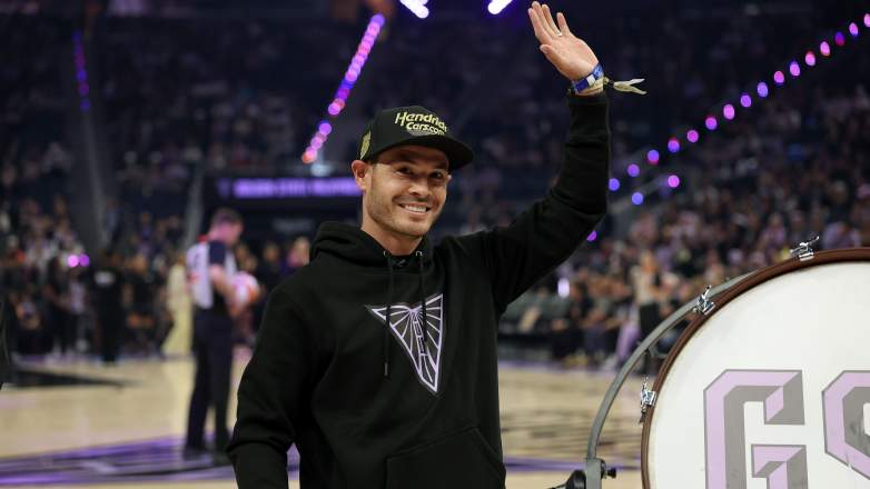 Kyle Larson waves to fans during a Golden State Valkyries WNBA game in San Francisco