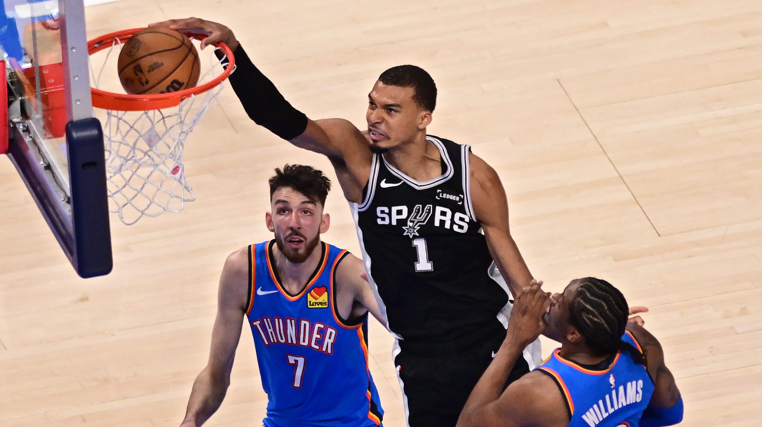 Victor Wembanyama dunks over Thunder defenders during Game 1