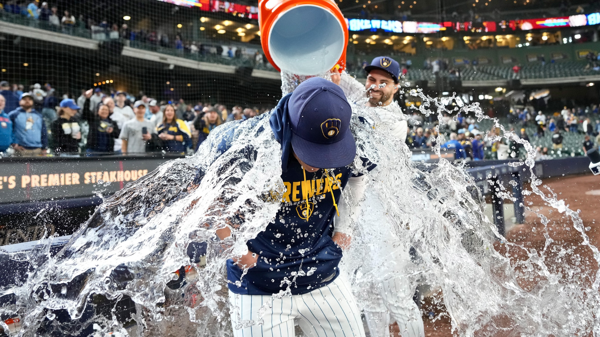 Garrett Mitchell #5 dumps water on Kyle Harrison #52 of the Milwaukee Brewers after a 5-0 win over the Pittsburgh Pirates at American Family Field on April 26, 2026 in Milwaukee, Wisconsin. (Photo by John Fisher/Getty Images)