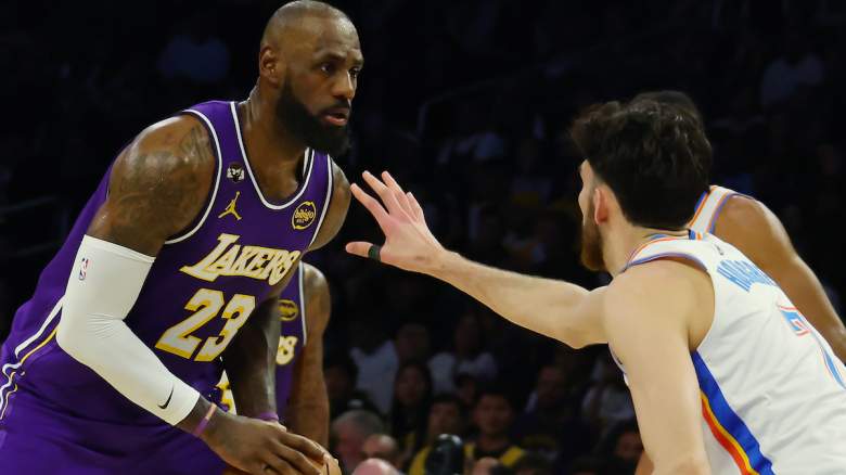 LeBron James de Los Angeles Lakers maneja el balón mientras lo defiende un jugador del Oklahoma City Thunder durante un partido de la temporada regular de la NBA.