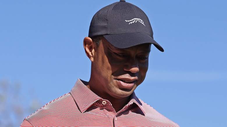 Tiger Woods looks down during a golf appearance amid reports he is nearing a return after completing a major rehab milestone.