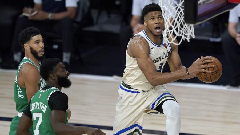 Milwaukee Bucks forward Giannis Antetokounmpo drives to the basket during a game against the Boston Celtics as Celtics stars Jayson Tatum and Jaylen Brown watch from the paint.