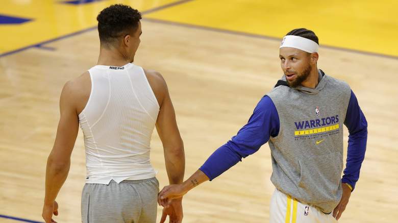 Golden State Warriors guard Stephen Curry talks with forward Michael Porter Jr. during pregame warmups before an NBA game.
