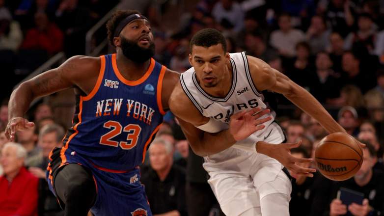 San Antonio Spurs forward Victor Wembanyama dribbles past New York Knicks center Mitchell Robinson during an NBA Finals game in San Antonio.