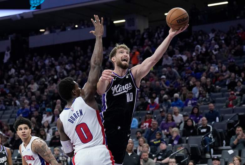 Sacramento Kings center Domantas Sabonis drives to the basket against Detroit Pistons center Jalen Duren during an NBA game.
