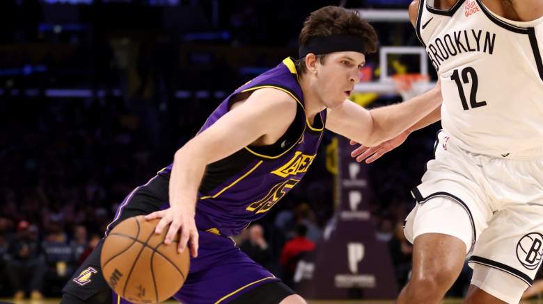 Austin Reaves dribbles against a Brooklyn Nets defender during a Lakers game as free agency speculation intensifies.