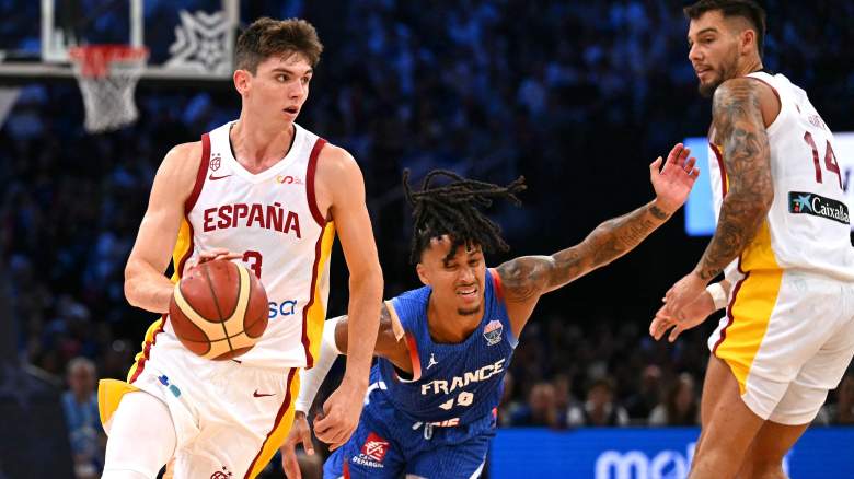 Spain's Sergio de Larrea dribbles up the court against France during international competition, displaying the ball-handling and playmaking skills that have attracted NBA scouts.