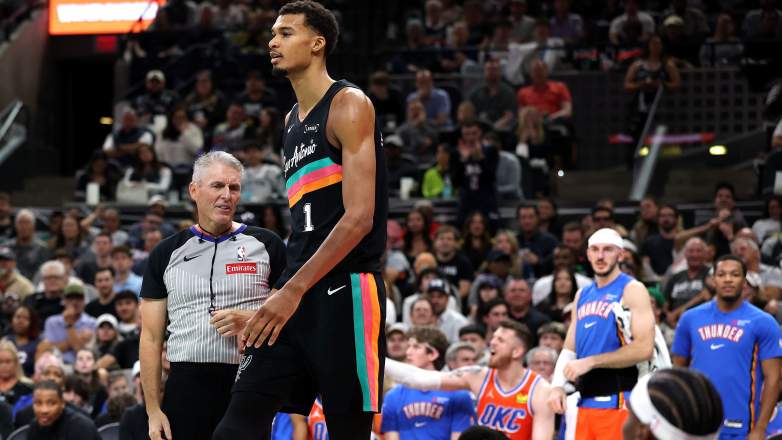 NBA referee Scott Foster stands near San Antonio Spurs star Victor Wembanyama during an NBA game.
