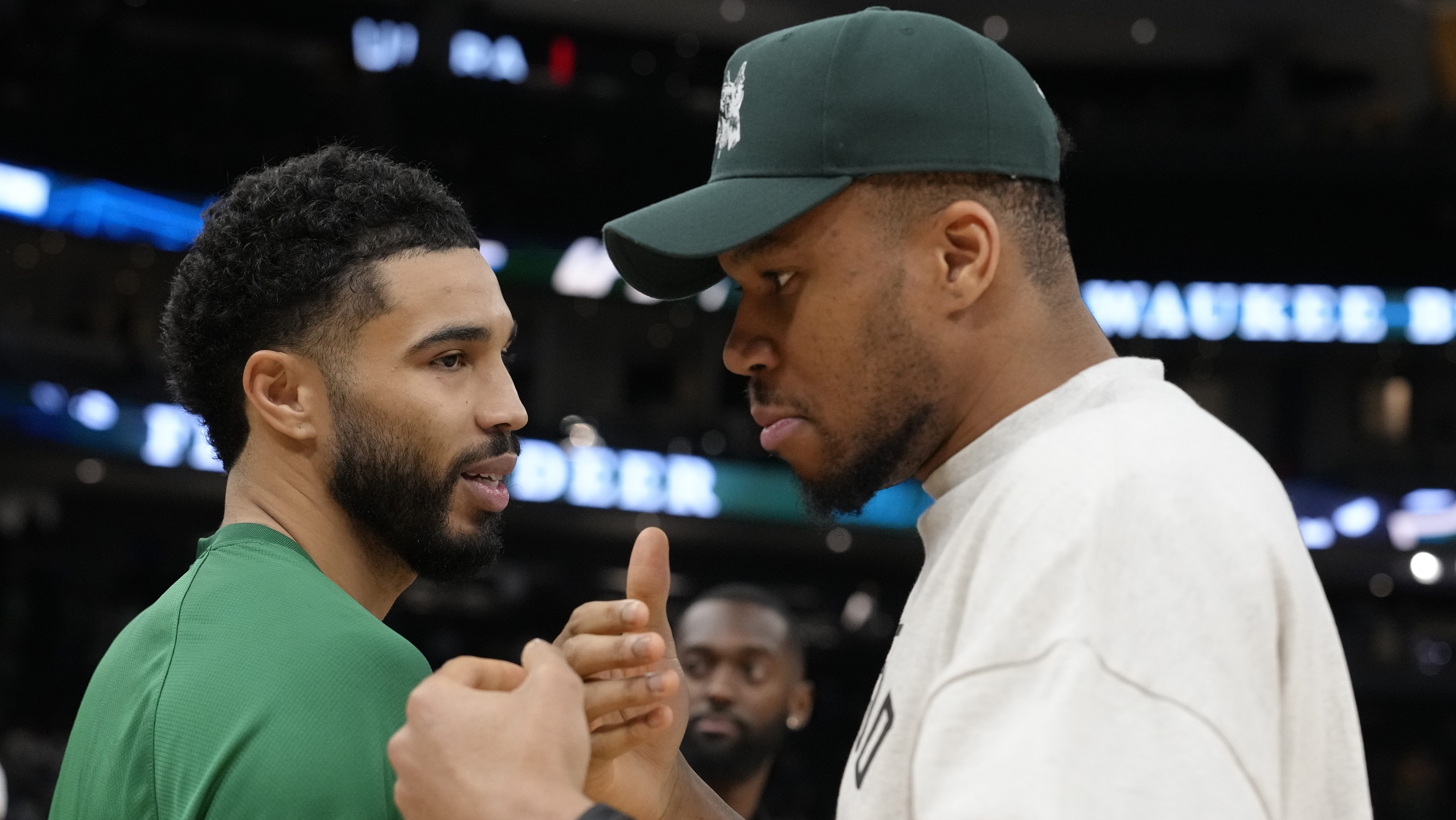 Boston Celtics star Jayson Tatum talks with Milwaukee Bucks superstar Giannis Antetokounmpo before an NBA game.