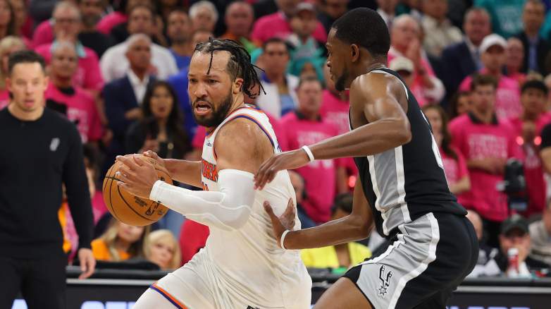 Jalen Brunson of the New York Knicks backs down a San Antonio Spurs' De'Aaron Fox during Game 1 of the 2026 NBA Finals at Frost Bank Center.