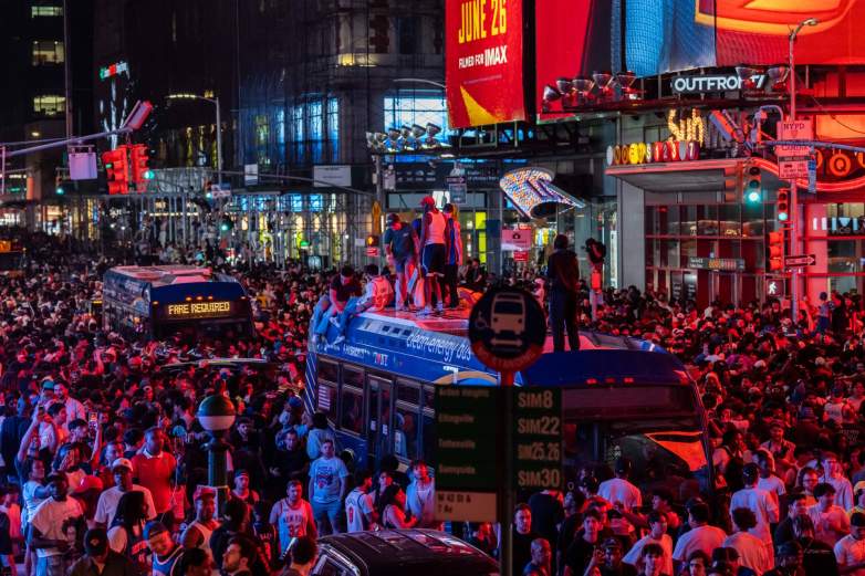 New York Knicks fans climb on buses as they celebrate after they win the NBA Finals