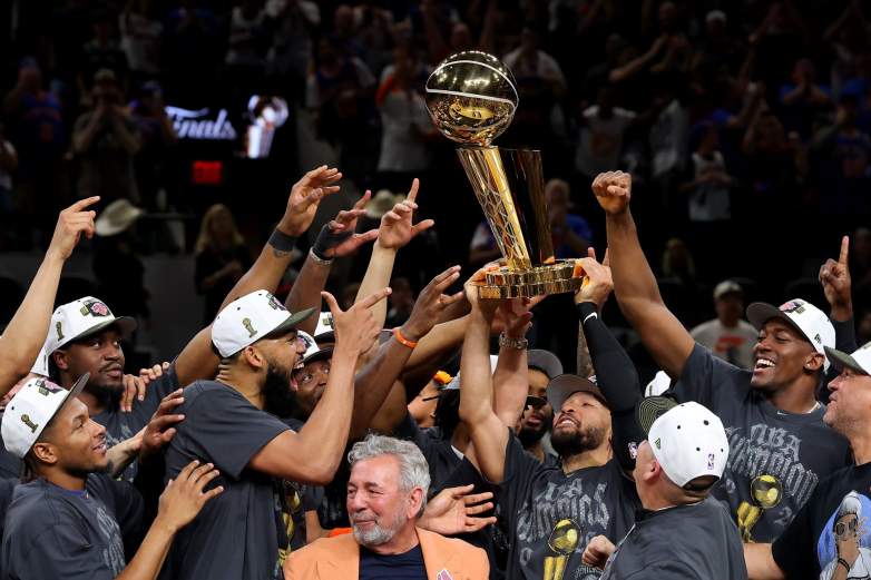 Jalen Brunson of the New York Knicks lifts the Larry O'Brien Championship Trophy