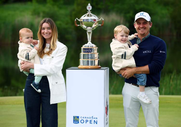 Bud Cauley of the United States poses with the trophy after his winning putt with his wife Kristi and their two young sons