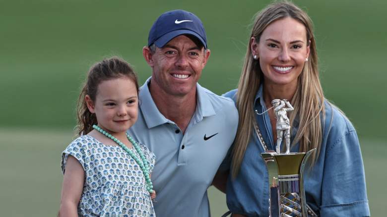 Northern Ireland's Rory McIlroy poses with his wife Erica Stoll and their daughter as he celebrates with his trophy at the end the 2025 DP World Tour Championship at Jumeirah Golf Estates in Dubai on November 16, 2025