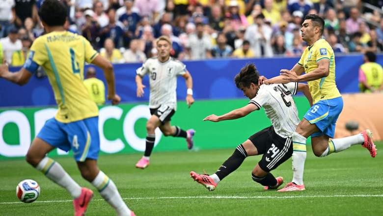Japan's midfielder #24 Kaishu Sano (C) shoots and scores the opening goal.