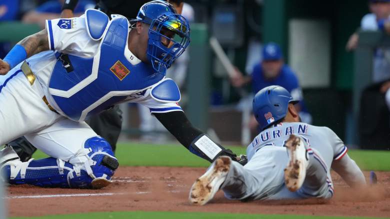 Salvador Perez #13 of the Kansas City Royals tags out Ezequiel Duran #20 of the Texas Rangers