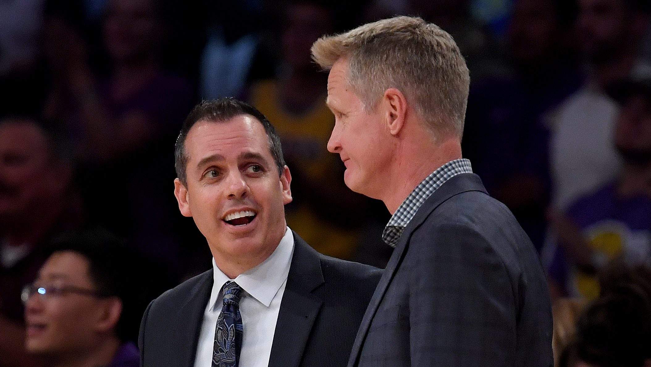 Steve Kerr talks with Frank Vogel before an NBA game after the Warriors hired Vogel as associate head coach.