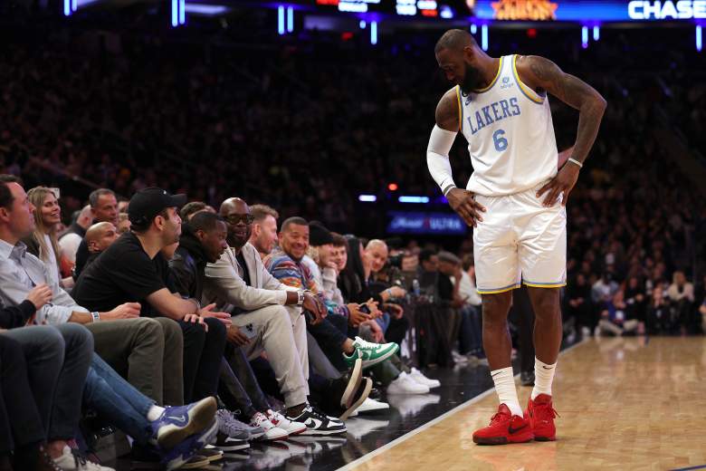 LeBron James stands near longtime agent Rich Paul, seated courtside during a Los Angeles Lakers game.