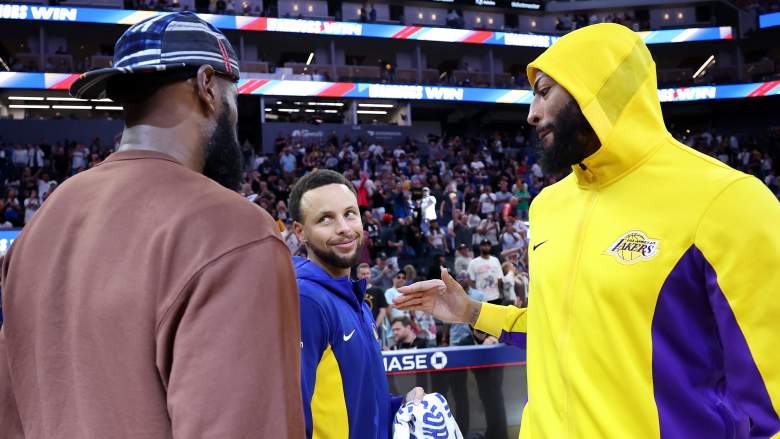 Stephen Curry shakes hands with LeBron James while Anthony Davis looks on after a Warriors-Lakers game.