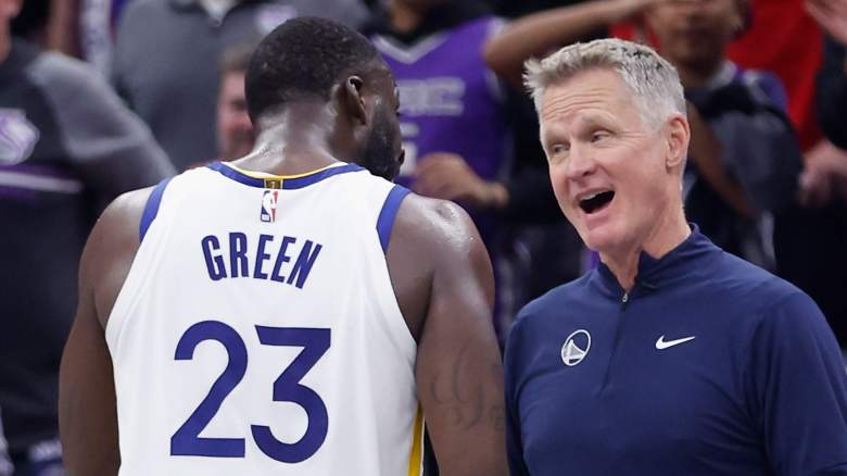 Golden State Warriors head coach Steve Kerr speaks with Draymond Green during an NBA game.